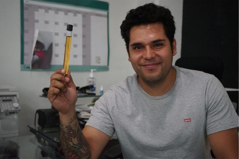 Moises Flores with a test tube sample of his biodiesel